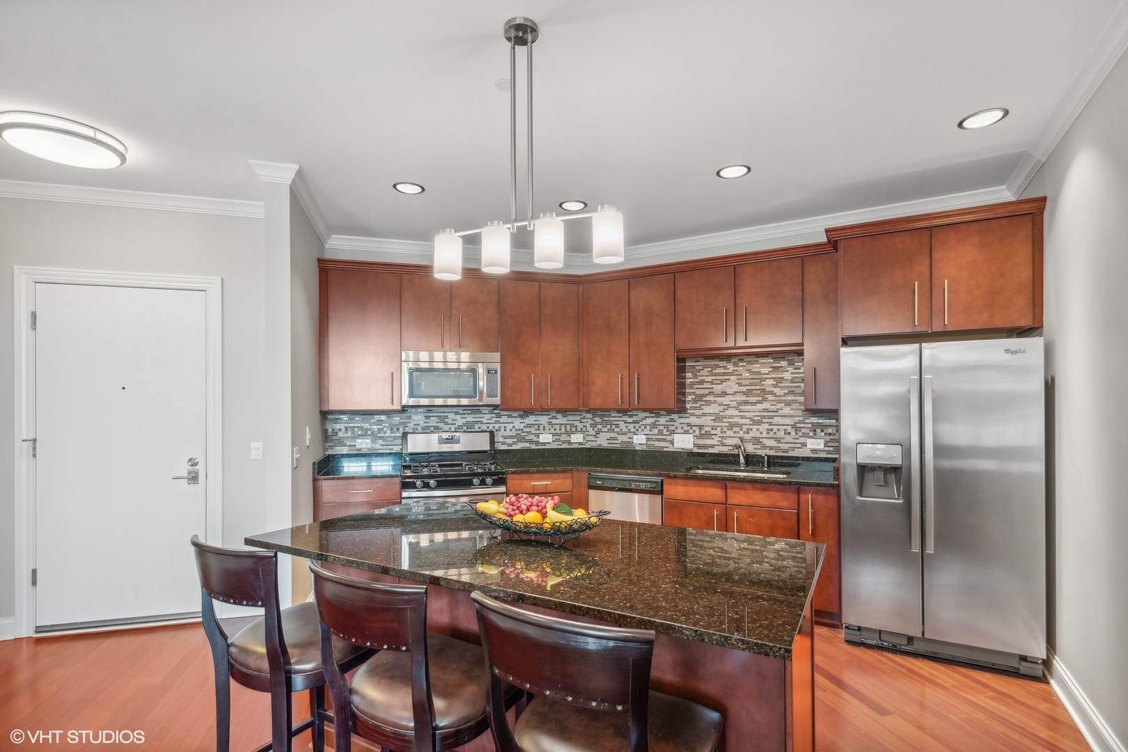100 Prairie Park Drive, Unit 401 Wheeling, IL 60090 - Photo 7 of 29 a kitchen with a dining table chairs stainless steel appliances and cabinets