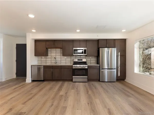 a kitchen with stainless steel appliances a refrigerator and a stove top oven