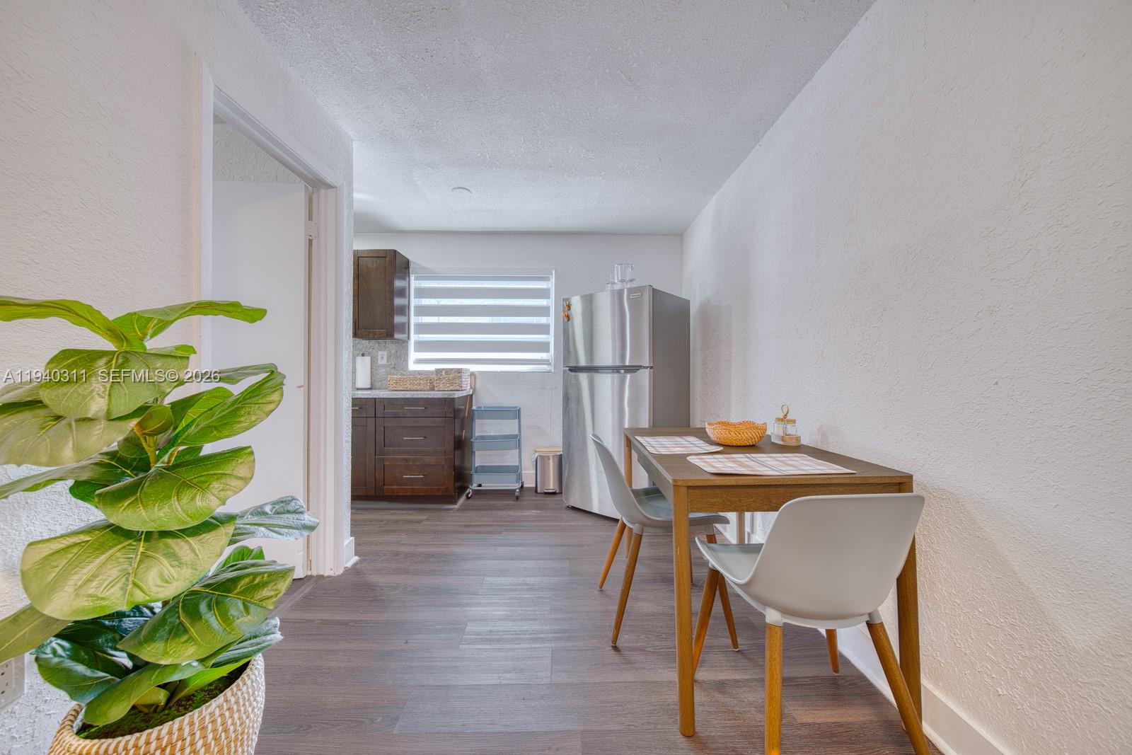 2741 Southwest 67th Avenue, Unit 1 Miami, FL 33155 - Photo 4 of 24 a view of a workspace with furniture and a potted plant