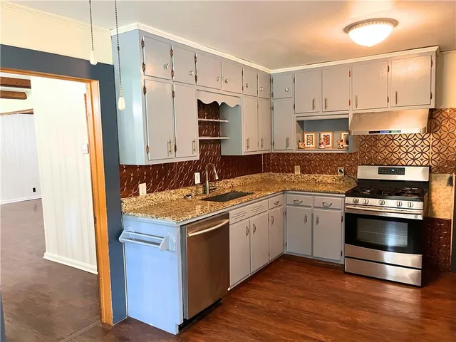 a kitchen with stainless steel appliances granite countertop a stove and a sink