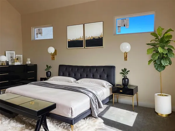 a bedroom with a bed and a potted plant on dresser