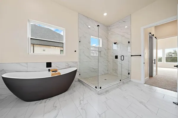 a spacious bathroom with a tub shower and mirror