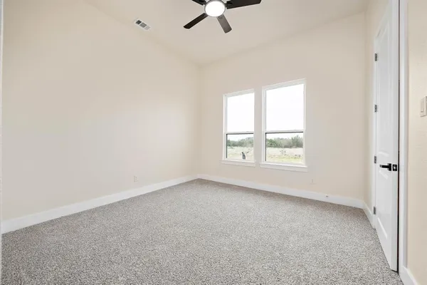 an empty room with a window and a ceiling fan