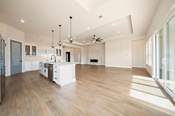 a view of a kitchen with kitchen island wooden floors stainless steel appliances and a window
