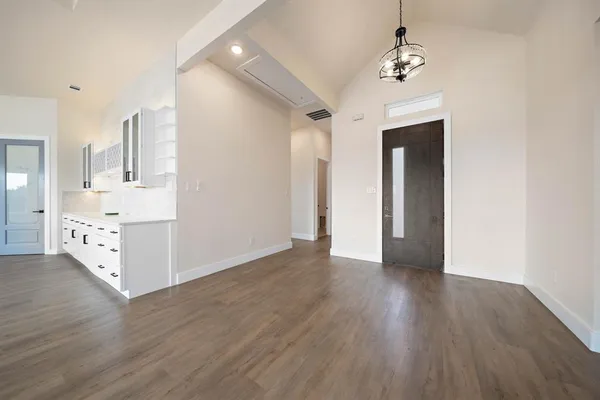 a view of a room with wooden floor and chandelier