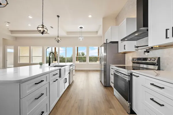 a kitchen with stainless steel appliances kitchen island granite countertop a stove a sink and a refrigerator