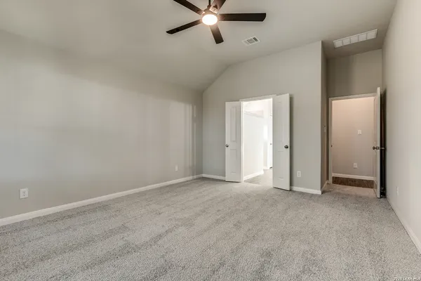 an empty room with fan and entrance