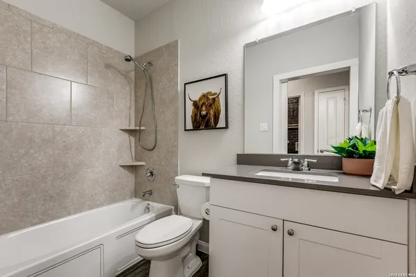 a bathroom with a granite countertop toilet a sink and a bathtub