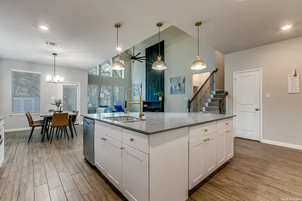 a kitchen with counter space dining table and wooden floor