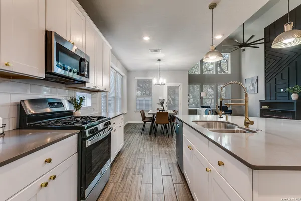 a kitchen with stainless steel appliances granite countertop a sink stove and microwave