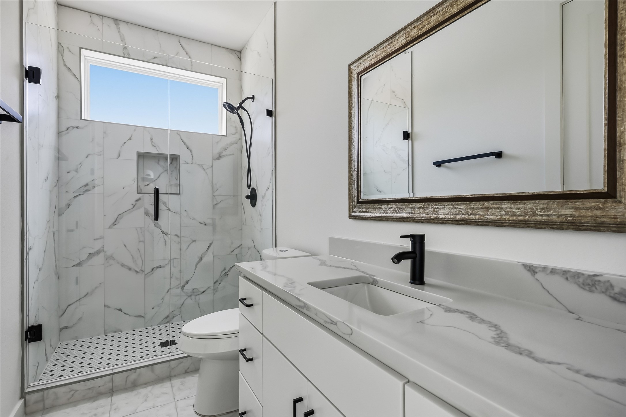 6809 Porter Street, Unit 1 Austin, TX 78741 - Photo 29 of 40 A well-lit bathroom features a spacious vanity with sleek countertops and a walk-in shower with elegant tile work.