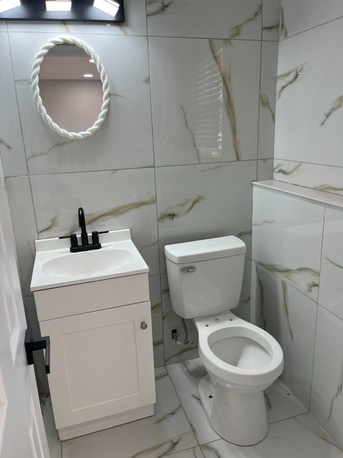 2405 Limestone Road Wilmington, DE 19808 - Photo 38 of 40 a bathroom with a toilet a sink and a mirror