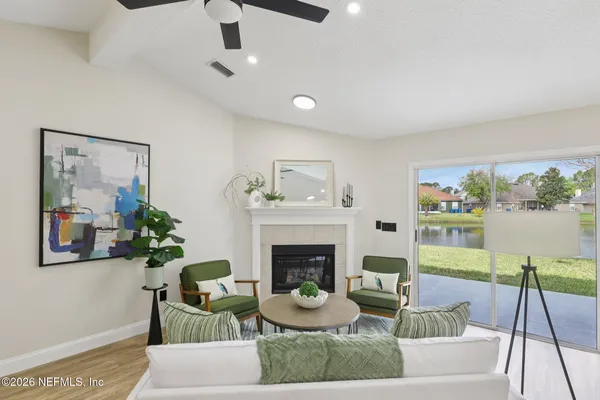 a living room with furniture a fireplace and a large mirror
