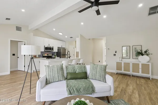 a living room with furniture and a view of kitchen