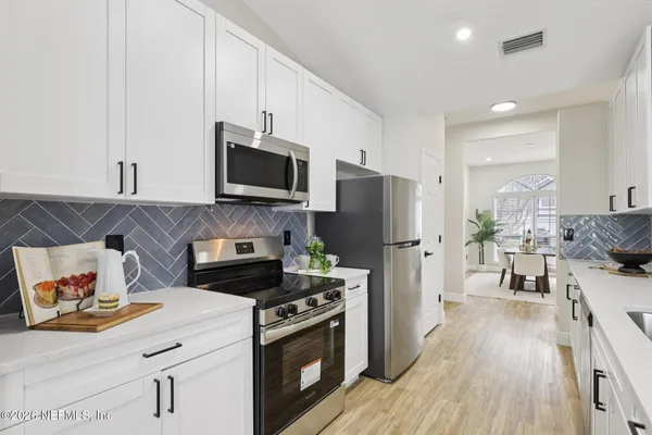 a kitchen with stainless steel appliances a stove microwave and refrigerator
