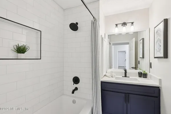 a bathroom with a bathtub shower sink and mirror