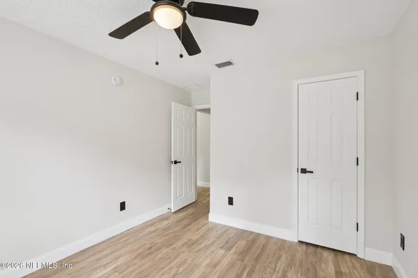 a view of empty room with wooden floor