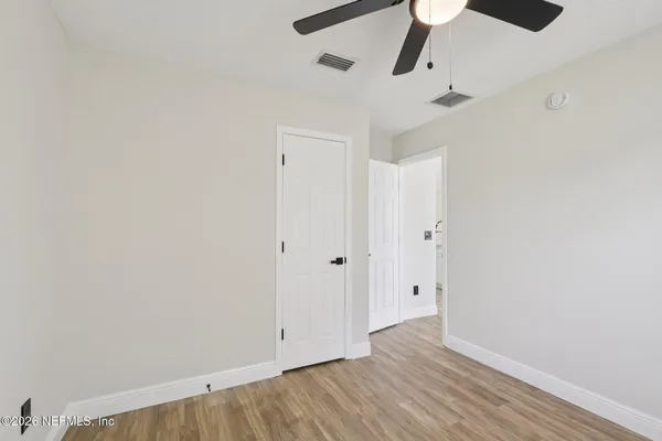 a view of an empty room with wooden floor