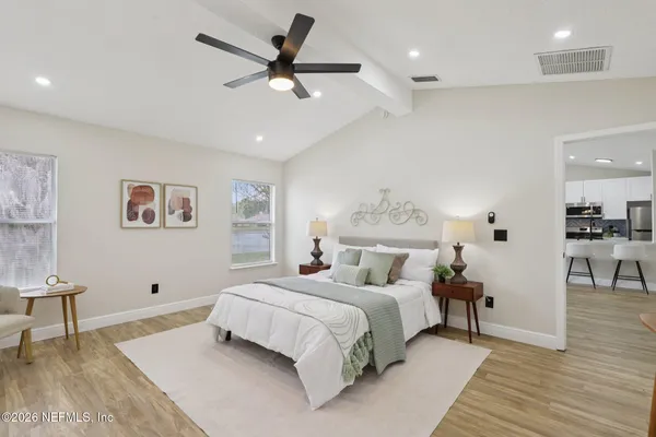a bedroom with a large bed and a chandelier