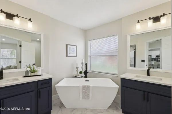 a bathroom with a sink a bathtub and a mirror