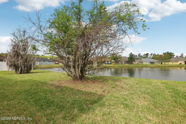 a backyard of a house with lots of green space and lake view
