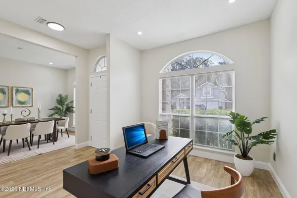 a living room with furniture potted plant and a large window
