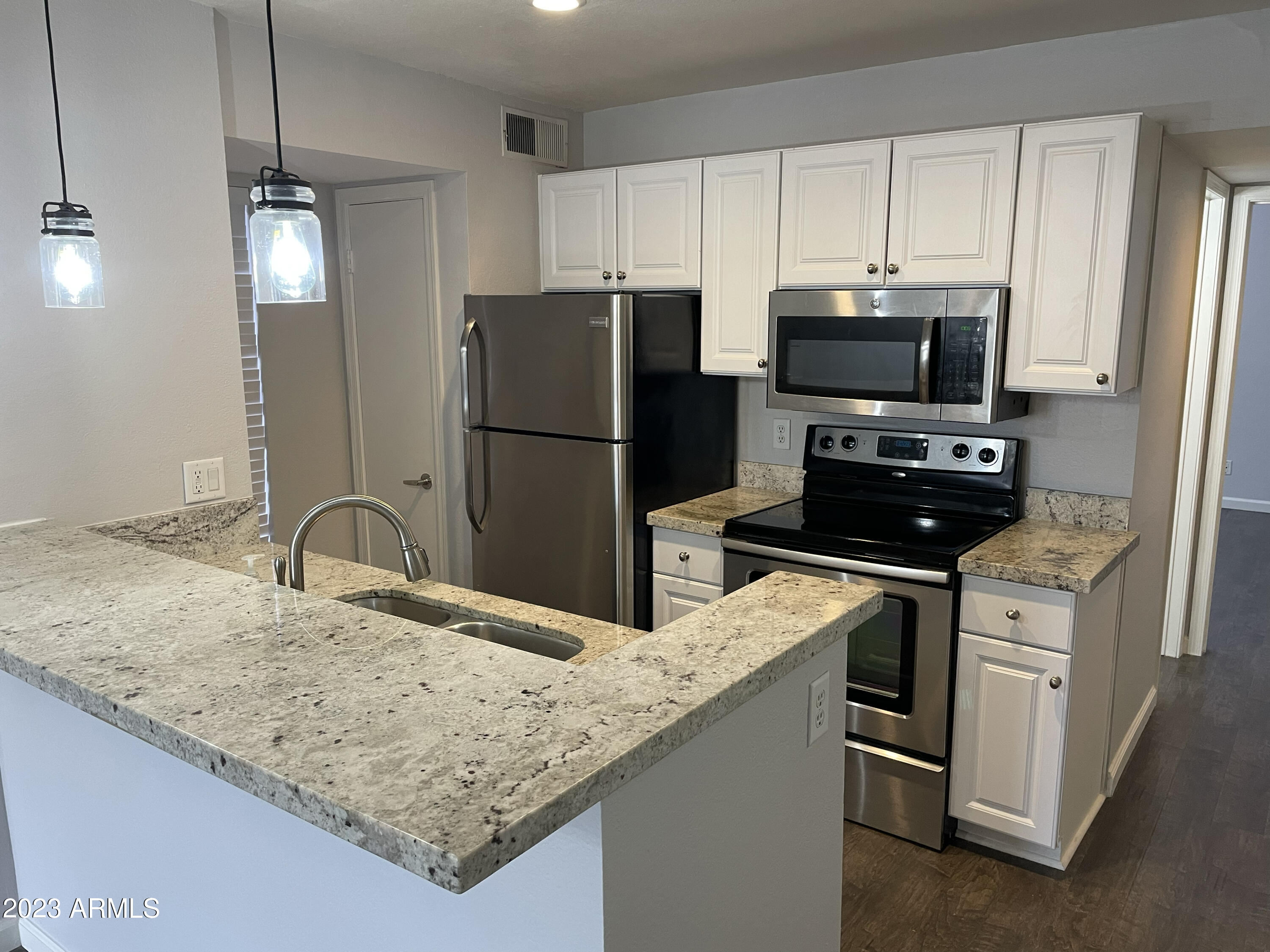 19820 North 13th Avenue, Unit 206 Phoenix, AZ 85027 - Photo 7 of 22 a kitchen with stainless steel appliances granite countertop a refrigerator a stove a sink a microwave and island