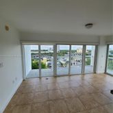 a view of an empty room with windows and balcony