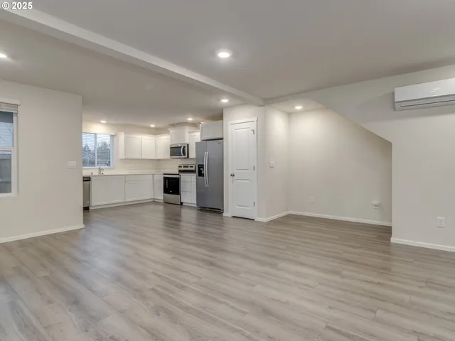 a view of an empty room with a kitchen