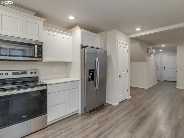 a kitchen with a refrigerator stove and wooden cabinets