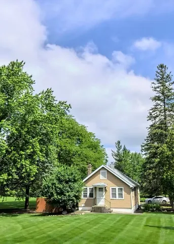 a house with green field in front of it