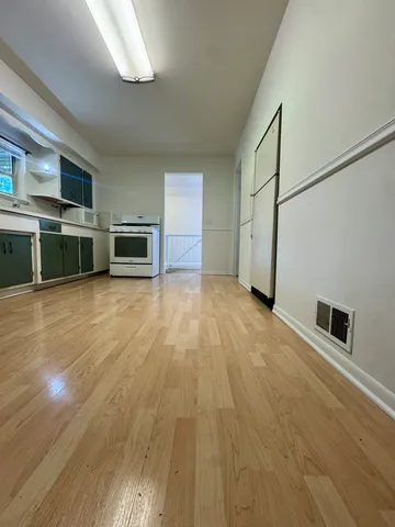 a view of a kitchen with stainless steel appliances wooden floor and a large window
