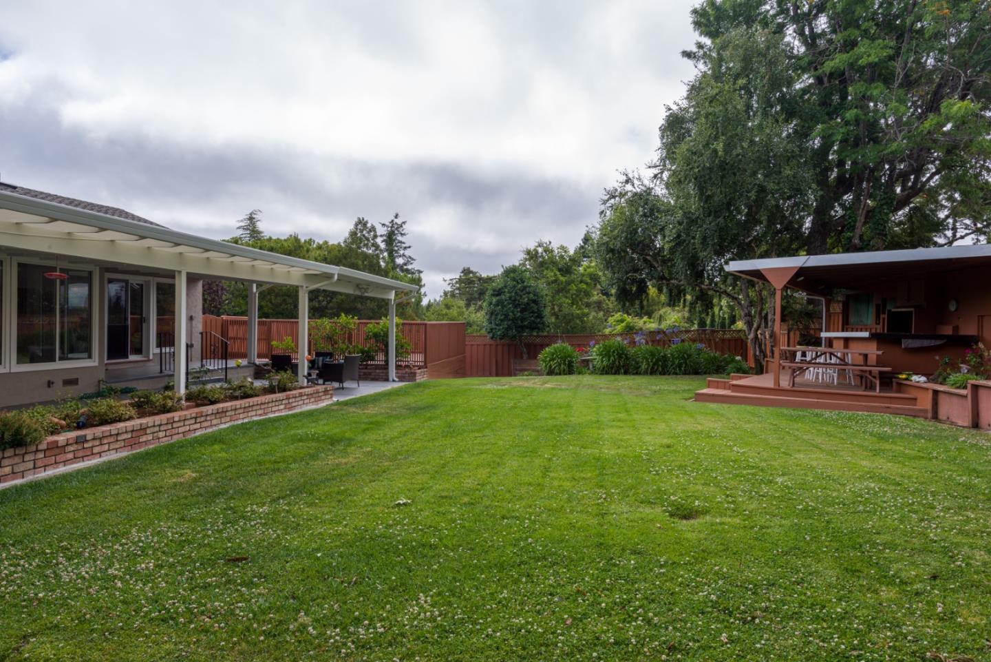 95 Avondale Road Hillsborough, CA 94010 - Photo 24 of 25 a view of a patio with table and chairs under an umbrella