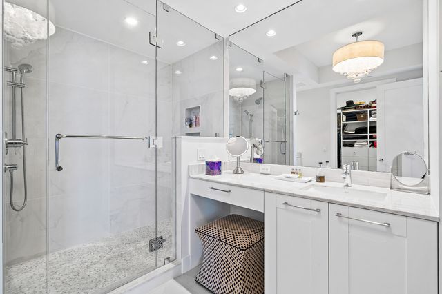a bathroom with a double vanity sink mirror and shower