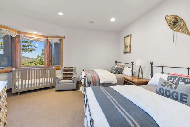 a bedroom with a bed and a large window