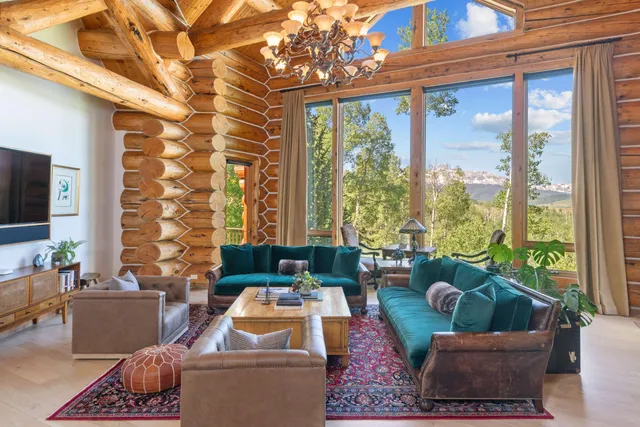 a living room with furniture a rug and a floor to ceiling window