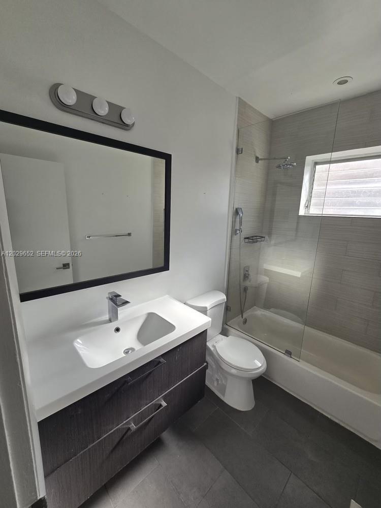 855 80th Street, Unit 4 Miami Beach, FL 33141 - Photo 13 of 16 a bathroom with a double vanity sink toilet and shower
