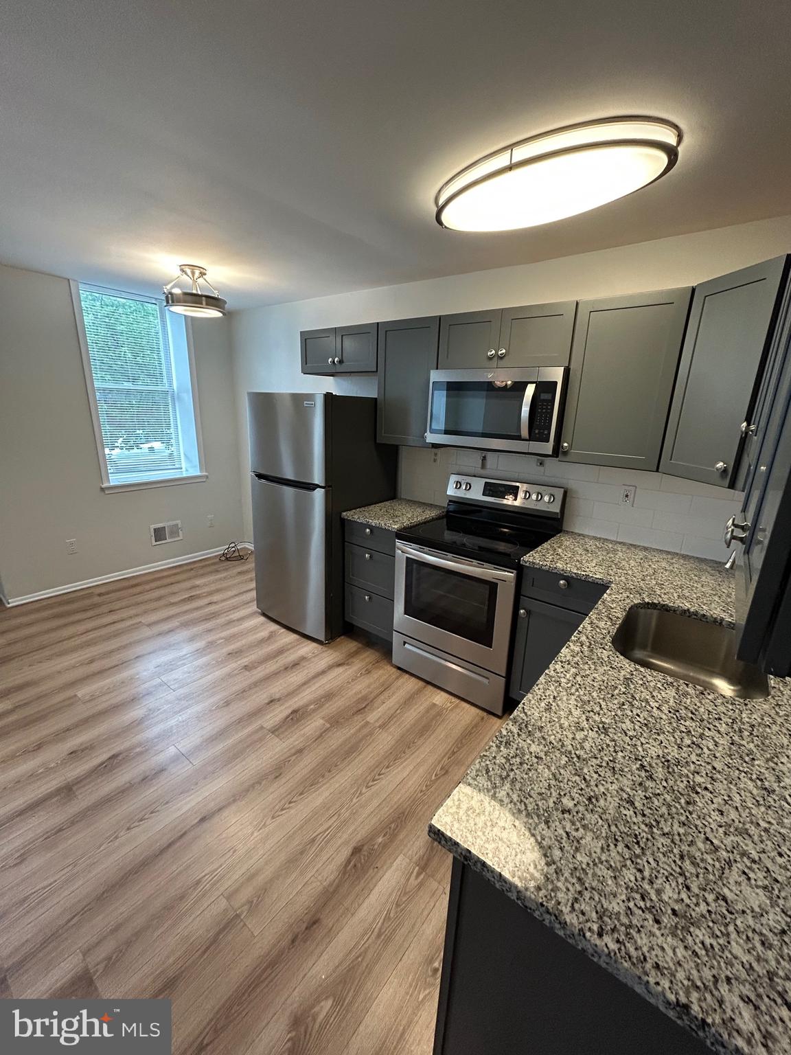 521 South Wolfe Street, Unit 1F Baltimore, MD 21231 - Photo 4 of 10 a kitchen with a stove a refrigerator and a sink