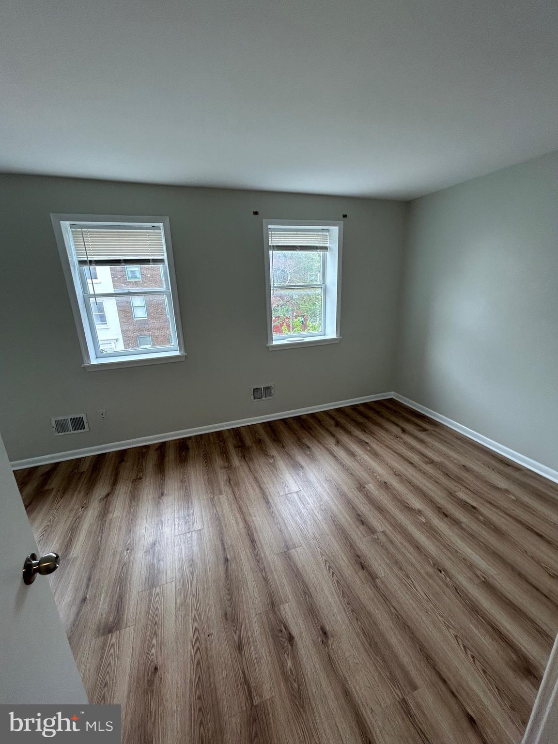 521 South Wolfe Street, Unit 1F Baltimore, MD 21231 - Photo 6 of 10 an empty room with wooden floor and windows
