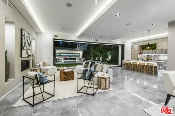 a kitchen with stainless steel appliances granite countertop sink stove and white cabinets next to a window