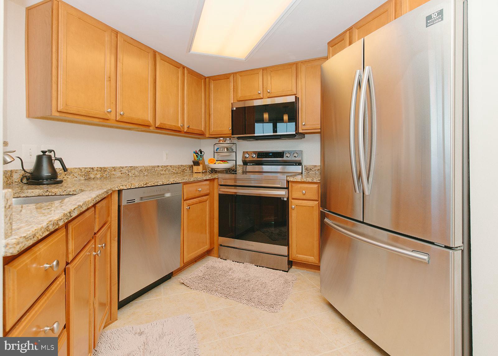 11800 Sunset Hills Road, Unit 506 Reston, VA 20190 - Photo 12 of 30 a kitchen with stainless steel appliances granite countertop a refrigerator sink and cabinets