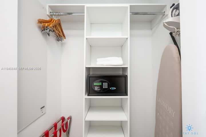 2602 East Hallandale Beach Boulevard, Unit R2006 Hallandale Beach, FL 33009 - Photo 17 of 24 a bedroom with a bed and a walk in closet