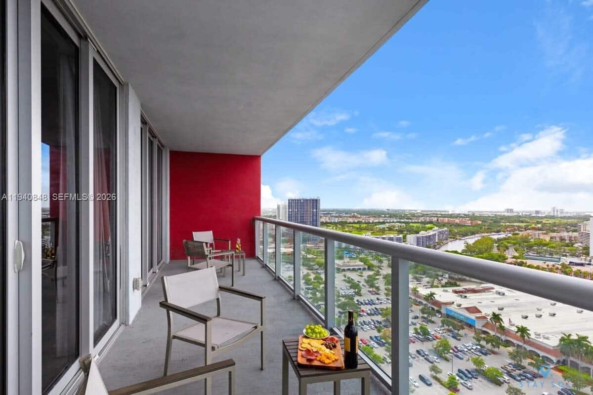 2602 East Hallandale Beach Boulevard, Unit R2006 Hallandale Beach, FL 33009 - Photo 21 of 24 a view of a balcony with chairs and wooden floor