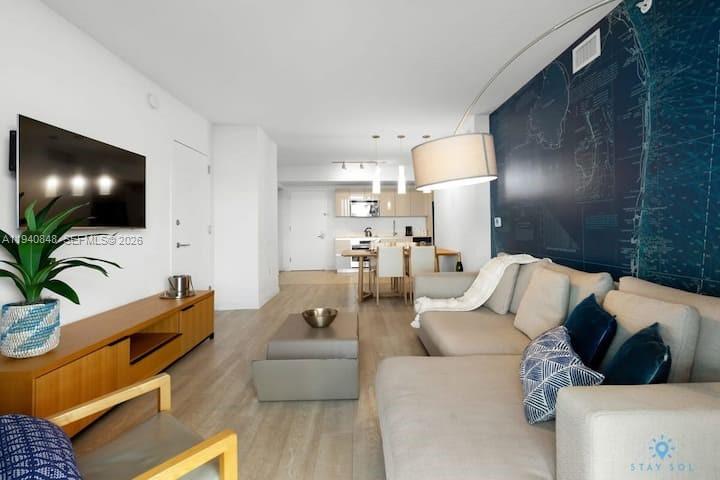 2602 East Hallandale Beach Boulevard, Unit R2006 Hallandale Beach, FL 33009 - Photo 7 of 24 a living room with furniture and a flat screen tv