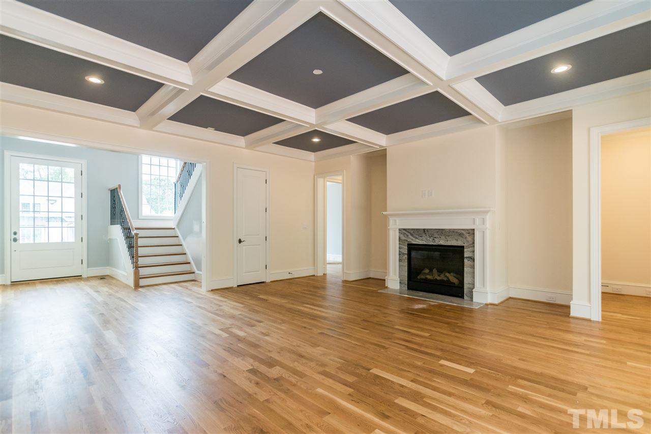 5412 Winding View Lane Raleigh, NC 27615 - Photo 4 of 30 an empty room with wooden floor a fireplace and windows