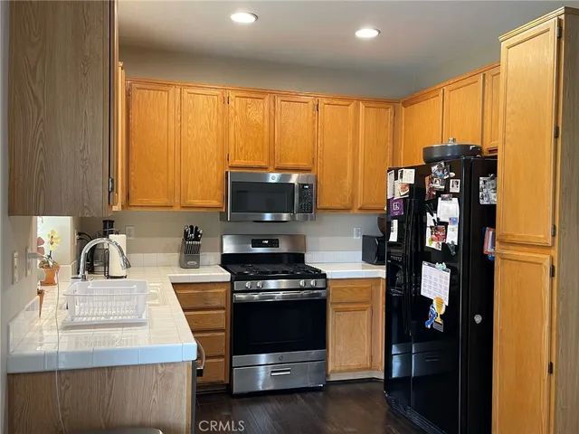 a kitchen with stainless steel appliances a stove a sink and white cabinets