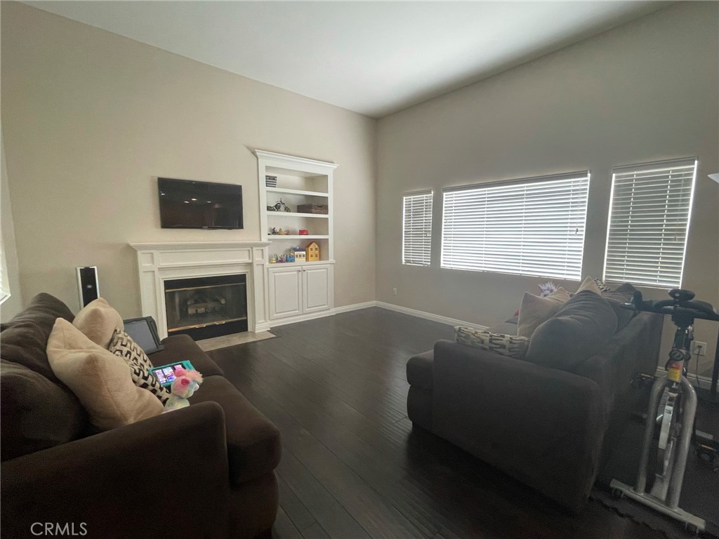43093 Teramo Street Temecula, CA 92592 - Photo 5 of 13 a living room with furniture a flat screen tv and a fireplace