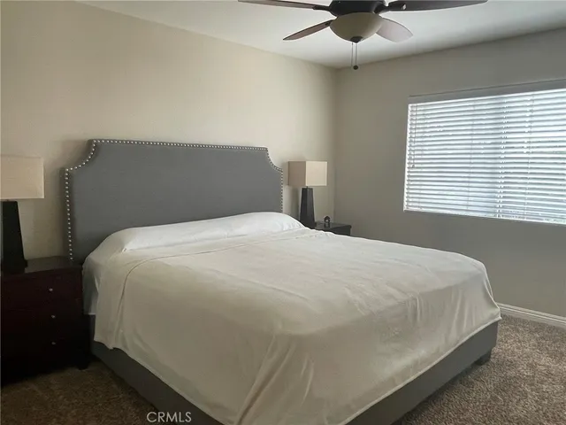 a large bed sitting in a bedroom next to a window