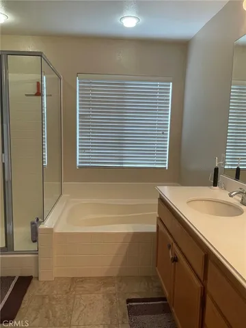 a bathroom with a granite countertop sink and a bathtub