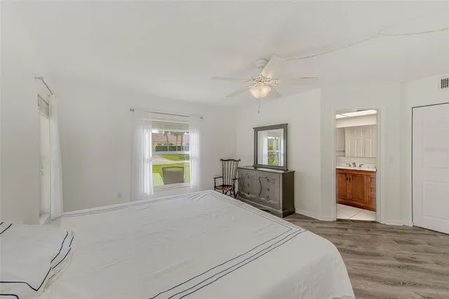 a view of a livingroom with furniture a ceiling fan and hardwood floor